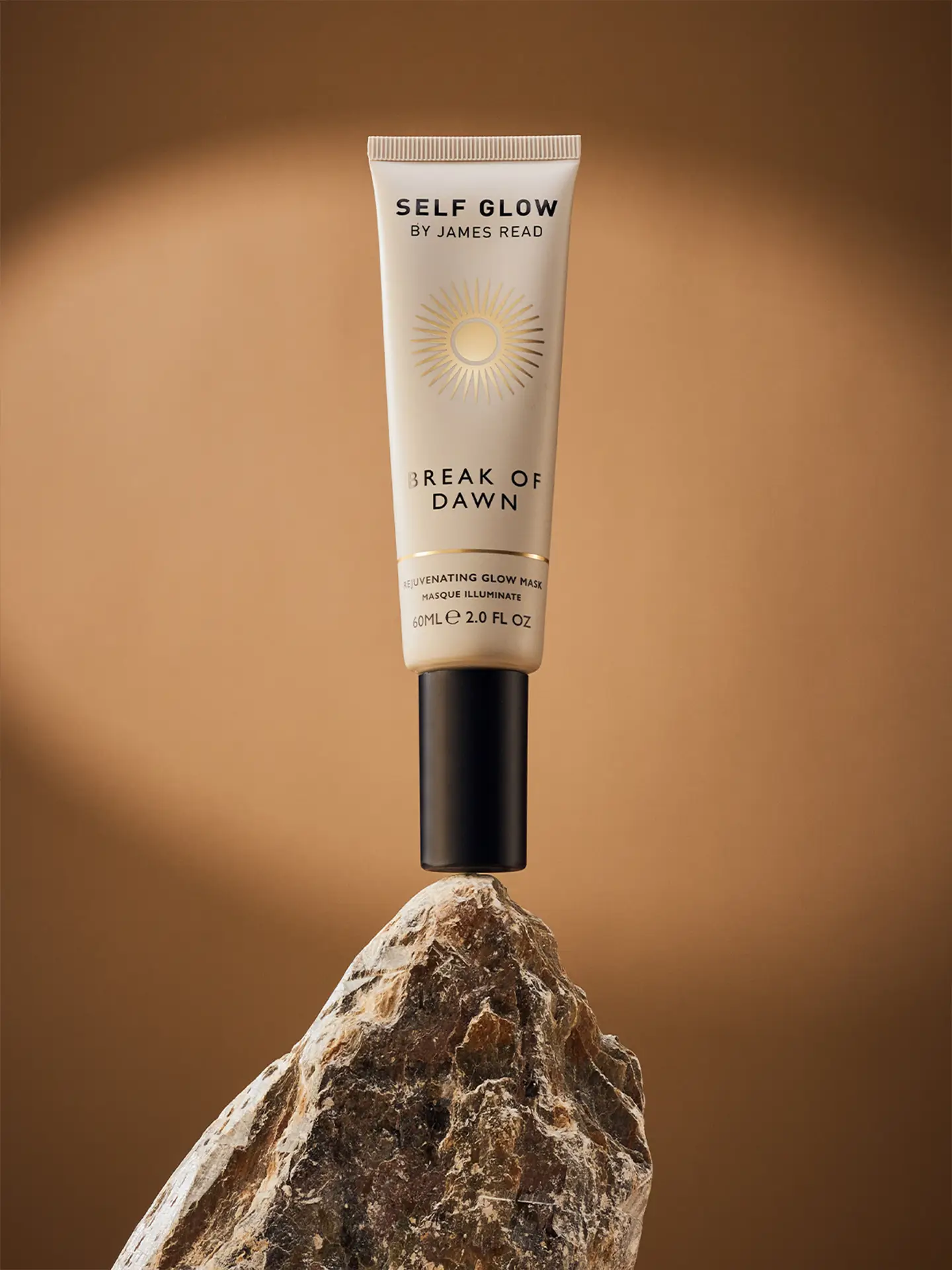 Premium packaging design by Saltco for Self Glow’s ‘Break of Dawn’ mask, shown standing on a rock with a warm bronze backdrop