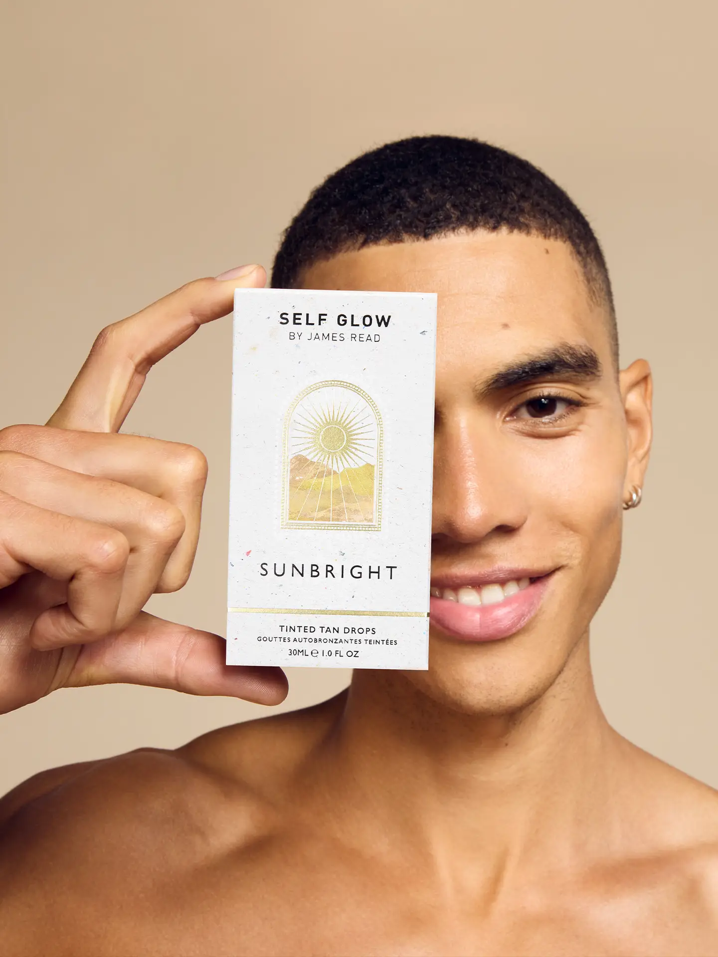 Self Glow by James Read ‘Sunbright’ carton held by model smiling into camera, created as part of Saltco campaign shoot